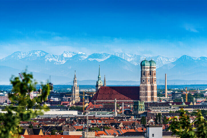 München Stadt Foto über Skyline mit Blick auf Dom Frauenkirche und Alpen-Gebirge im Hintergrund